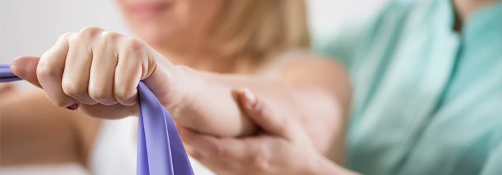 Close-up of hands stretching a purple resistance band