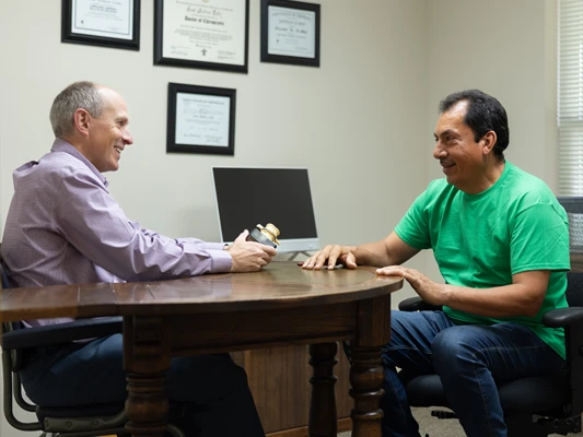 Dr. Scott Lally conducting a new patient consultation and spinal health review at Lally Chiropractic Clinic in Yakima, WA.