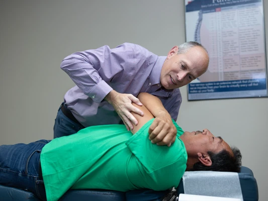 Dr. Scott Lally performing a side-lying spinal adjustment on a patient at Lally Chiropractic Clinic in Yakima, WA.